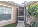 Inviting house entrance featuring a screen door, wreath, and landscaping at 4474 Connery Ct, Palm Harbor, FL 34685