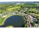 Aerial view of community featuring a lake, pool, tennis courts, and lush landscaping at 29129 S Bay Hollow S Dr # 3213, Wesley Chapel, FL 33543