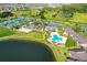 Aerial view of community amenities including tennis courts, pool, and lake at 29129 S Bay Hollow S Dr # 3213, Wesley Chapel, FL 33543