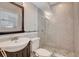 Modern bathroom featuring glass enclosed shower, stone flooring, sleek fixtures, and large mirror at 201 6Th S St # 106, St Petersburg, FL 33701