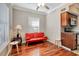 Cozy living area showcasing a red sofa, hardwood floors, and open access to the kitchen at 201 6Th S St # 106, St Petersburg, FL 33701