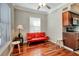 Bright living room featuring hardwood floors, a red futon, and a ceiling fan at 201 6Th S St # 106, St Petersburg, FL 33701
