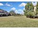 Lush green backyard featuring mature trees, a serene pond, and surrounding neighborhood residences at 20308 Oak Key Ct, Tampa, FL 33647