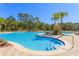 Large community pool area featuring multiple pools, comfortable lounge chairs, and lush tropical landscaping at 20308 Oak Key Ct, Tampa, FL 33647