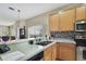 This kitchen offers stainless steel appliances, wood cabinets and a tiled backsplash at 20308 Oak Key Ct, Tampa, FL 33647