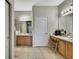 Open main bathroom with dual sinks, tiled floor, and a separate makeup vanity at 20308 Oak Key Ct, Tampa, FL 33647
