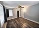 Well-lit bedroom with wood-look floors, ceiling fan, and a private door at 7006 N 18Th St, Tampa, FL 33610