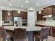 Stylish kitchen with large granite island and dark wood cabinets at 31982 Bourneville Ter, Wesley Chapel, FL 33543