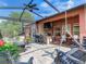 Large covered patio with outdoor kitchen and seating at 31982 Bourneville Ter, Wesley Chapel, FL 33543