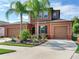 Two-story house with a two-car garage, palm trees, and a well-manicured front yard at 31982 Bourneville Ter, Wesley Chapel, FL 33543