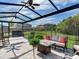 Spacious screened patio with seating, fire pit, and backyard view at 31982 Bourneville Ter, Wesley Chapel, FL 33543