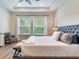 Main bedroom with king-size bed, light flooring, and natural light at 31982 Bourneville Ter, Wesley Chapel, FL 33543