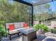 Covered patio with fire pit and comfortable seating area at 31982 Bourneville Ter, Wesley Chapel, FL 33543