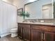 Bathroom features granite countertop, dark wood cabinets, and a shower/tub combo at 31982 Bourneville Ter, Wesley Chapel, FL 33543