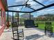 Relaxing screened porch with a swing and rocking chairs at 31982 Bourneville Ter, Wesley Chapel, FL 33543