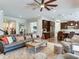 Open living room with a large leather sofa and view to kitchen at 31982 Bourneville Ter, Wesley Chapel, FL 33543