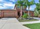 Two-story house with a two-car garage, palm trees, and a landscaped front yard at 31982 Bourneville Ter, Wesley Chapel, FL 33543