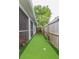 Landscaped backyard putting green, surrounded by fence and lush greenery at 1419 Trail Boss Ln, Brandon, FL 33511