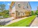 Beautiful side exterior of a townhome featuring beige walls, a private garage, and lush green landscaping along the walkway at 1425 Hillside Landing Dr, Tarpon Springs, FL 34688