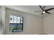 Bright bedroom featuring a large window with views and modern ceiling fan at 16850 Whisper Elm St, Wimauma, FL 33598