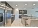 Modern kitchen featuring stainless steel appliances, a granite island with seating, and ample storage at 16850 Whisper Elm St, Wimauma, FL 33598