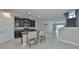 Open-concept kitchen flows into the living area and features a center island with barstool seating and modern lighting at 16850 Whisper Elm St, Wimauma, FL 33598