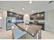 Modern kitchen featuring stainless steel appliances, a granite island, and sleek dark cabinetry at 16850 Whisper Elm St, Wimauma, FL 33598