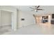 Bright, open-concept living room with tile flooring, ceiling fan, and staircase access at 16850 Whisper Elm St, Wimauma, FL 33598