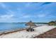 Picturesque beach featuring a tiki hut with picnic table, kayaks, and serene ocean views at 3730 42Nd S Way # H, St Petersburg, FL 33711