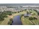 Aerial view of a neighborhood with a golf course and lake at 718 Camellia Green Dr, Sun City Center, FL 33573