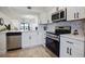 Modern kitchen with white cabinets, stainless steel appliances, and hexagon tile backsplash at 6291 Bahia Del Mar Cir # 103, St Petersburg, FL 33715