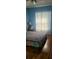 Bedroom with light blue walls, hardwood floors, and sheer curtains at 4432 Whitton Way, New Port Richey, FL 34653