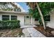 House entrance with light green door, brick walkway, and landscaping at 1001 Chinaberry Rd, Clearwater, FL 33764