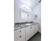 Bathroom with granite countertop, white cabinets, and large mirror at 1001 Chinaberry Rd, Clearwater, FL 33764