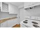Bright kitchen features white cabinets, countertops, and a modern electric stove at 233 W College Ave, Ruskin, FL 33570