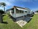 A modest home showing a small back patio with awnings and a grassy yard at 2331 Belleair Rd # Lot 237, Clearwater, FL 33764