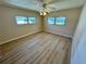 Bright bedroom with wood floors, a ceiling fan, and natural light from dual windows at 2331 Belleair Rd # Lot 237, Clearwater, FL 33764