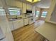 Bright kitchen features white appliances, wood floors, and a window above the sink at 2331 Belleair Rd # Lot 237, Clearwater, FL 33764