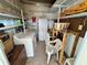 Interior storage room with shelves, washer, dryer, white storage cabinet, a table, and chairs at 2331 Belleair Rd # Lot 237, Clearwater, FL 33764