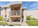 Two-story condo building features a private covered balcony, walkway, and manicured landscaping at 621 99Th N Ave # 102, St Petersburg, FL 33702