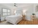 Bright bedroom with a white bed and light wood floors at 12 Gulf Blvd # B4, Indian Rocks Beach, FL 33785