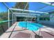 Inviting pool area with screened enclosure, lounge chairs, and a fun inflatable flamingo at 9011 Hunt Club Ln, Port Richey, FL 34668