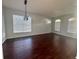 Bright living room featuring wood floors, large windows with blinds, and a contemporary light fixture at 1127 Barclay Wood Dr, Ruskin, FL 33570