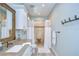 Modern bathroom featuring a walk-in shower, single vanity, and light blue walls at 262 Banana Rd, Palm Harbor, FL 34683