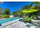 Pool area with lounge chairs and a vibrant green umbrella at 262 Banana Rd, Palm Harbor, FL 34683