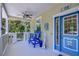 Welcoming front porch with a blue bench, charming decor, and a bright blue door at 262 Banana Rd, Palm Harbor, FL 34683