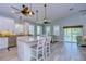 Open kitchen with island, white cabinets, and stainless steel appliances at 262 Banana Rd, Palm Harbor, FL 34683