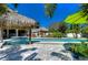 Relaxing pool area with tiki huts, a bright green umbrella, and ample space for lounging at 262 Banana Rd, Palm Harbor, FL 34683