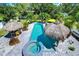 Aerial view of backyard oasis with pool, spa, and tiki huts at 262 Banana Rd, Palm Harbor, FL 34683