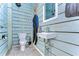 Small bathroom with nautical theme and wood paneling at 262 Banana Rd, Palm Harbor, FL 34683
